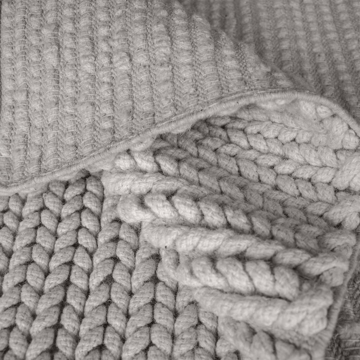 Dor handwoven chunky wool rug in charcoal, woven in thick cords, in a living room