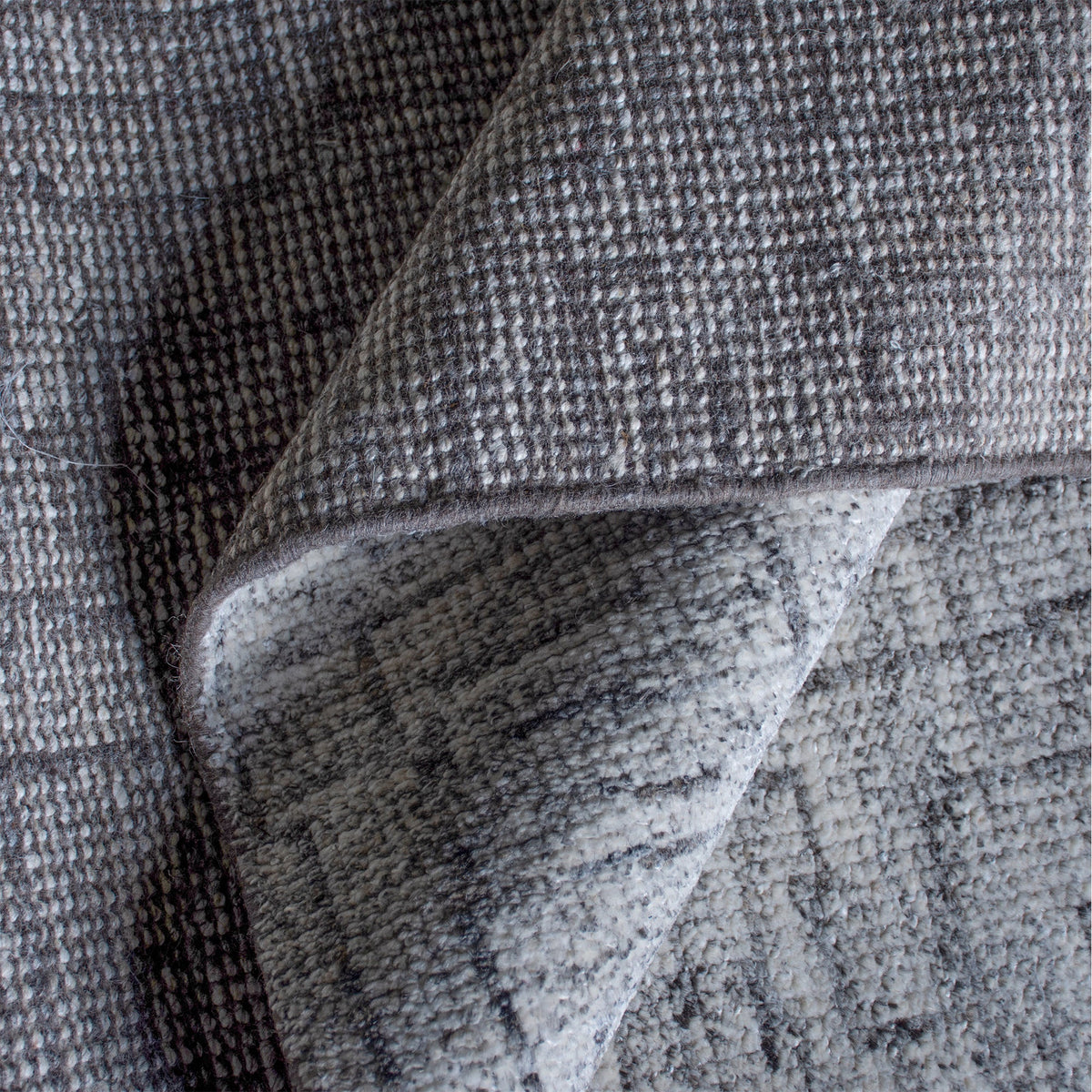 Barsaat hand-knotted wool and viscose rug with mottled blue-grey brick lines, in a living room