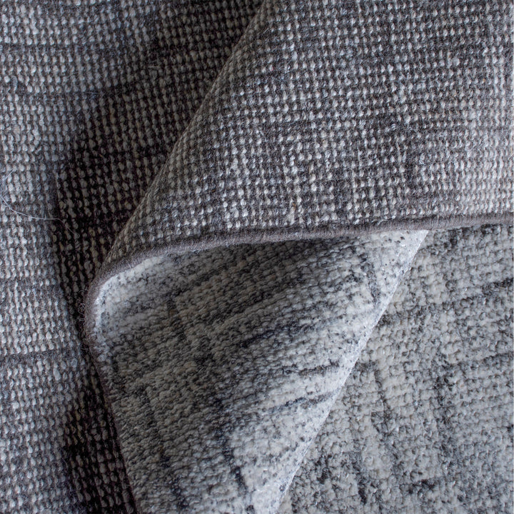 Barsaat hand-knotted wool and viscose rug with mottled blue-grey brick lines, in a living room