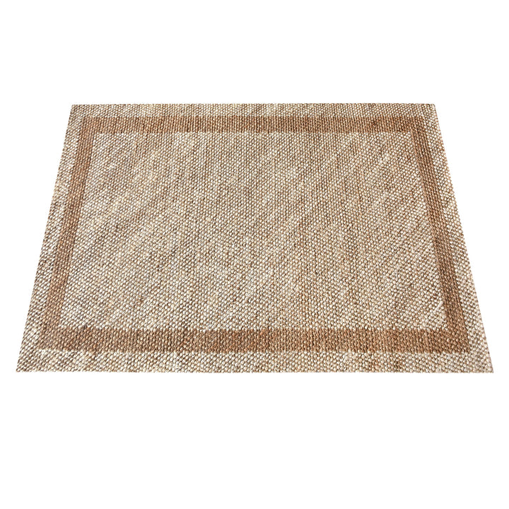 Chaukhat handwoven flatweave jute and wool rug in jute tan with a rust-brown border, in a living room