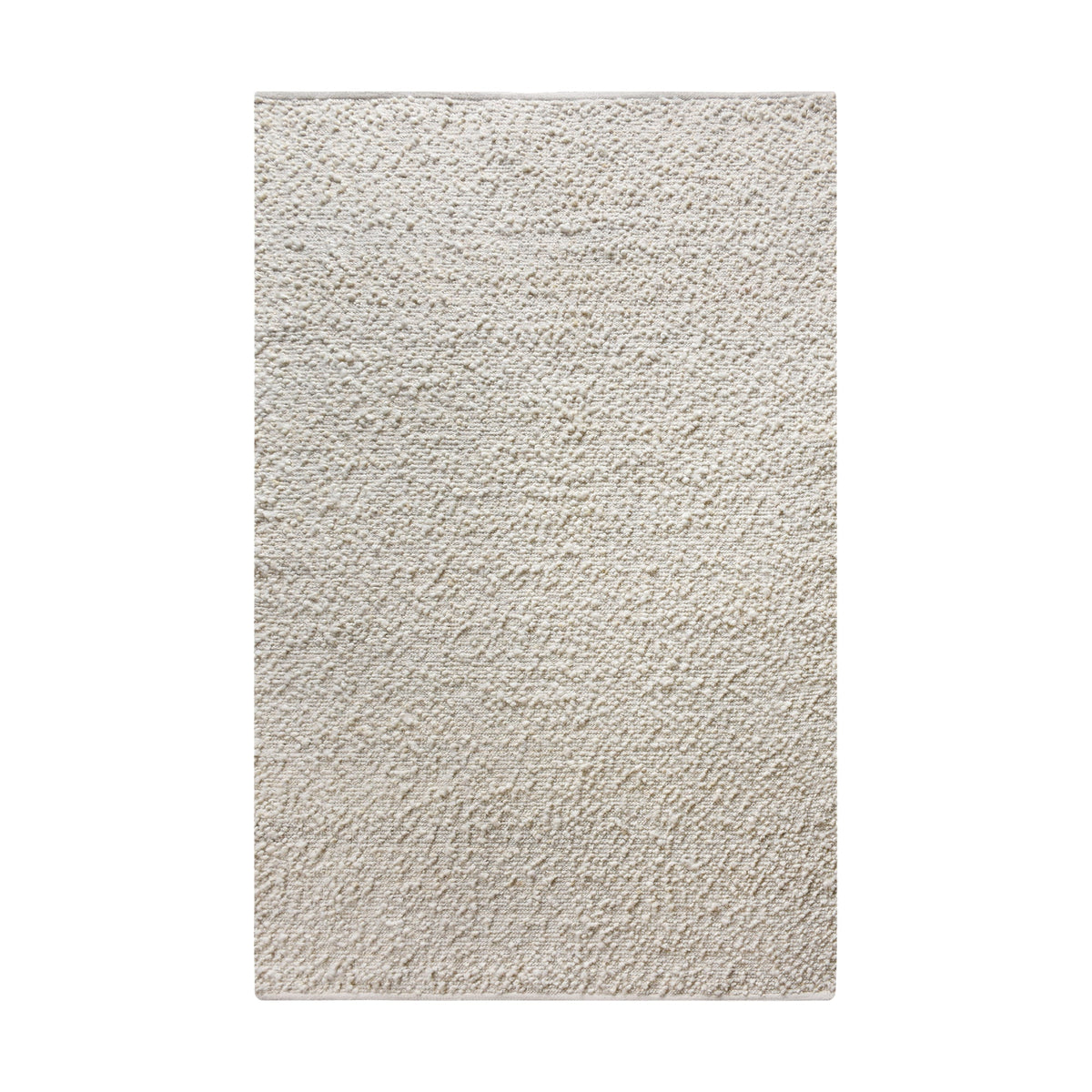 Lambswool handwoven ivory wool and jute rug with a bouclé pebble pile, in a living room