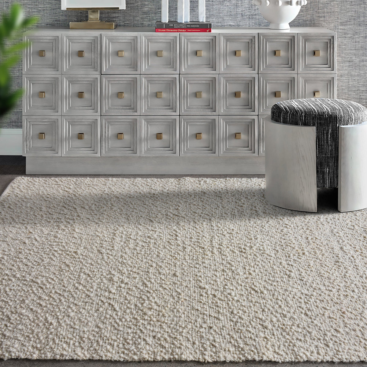 Lambswool handwoven ivory wool and jute rug with a bouclé pebble pile, in a living room