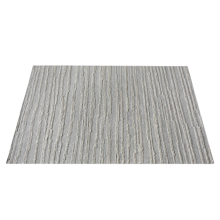 Surma hand-knotted wool rug in slate grey with raised ivory vertical stripes, in a living room