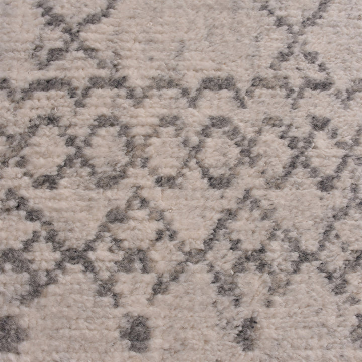 Phatak hand-knotted wool rug with an ivory diamond lattice and grey border, in a dining room