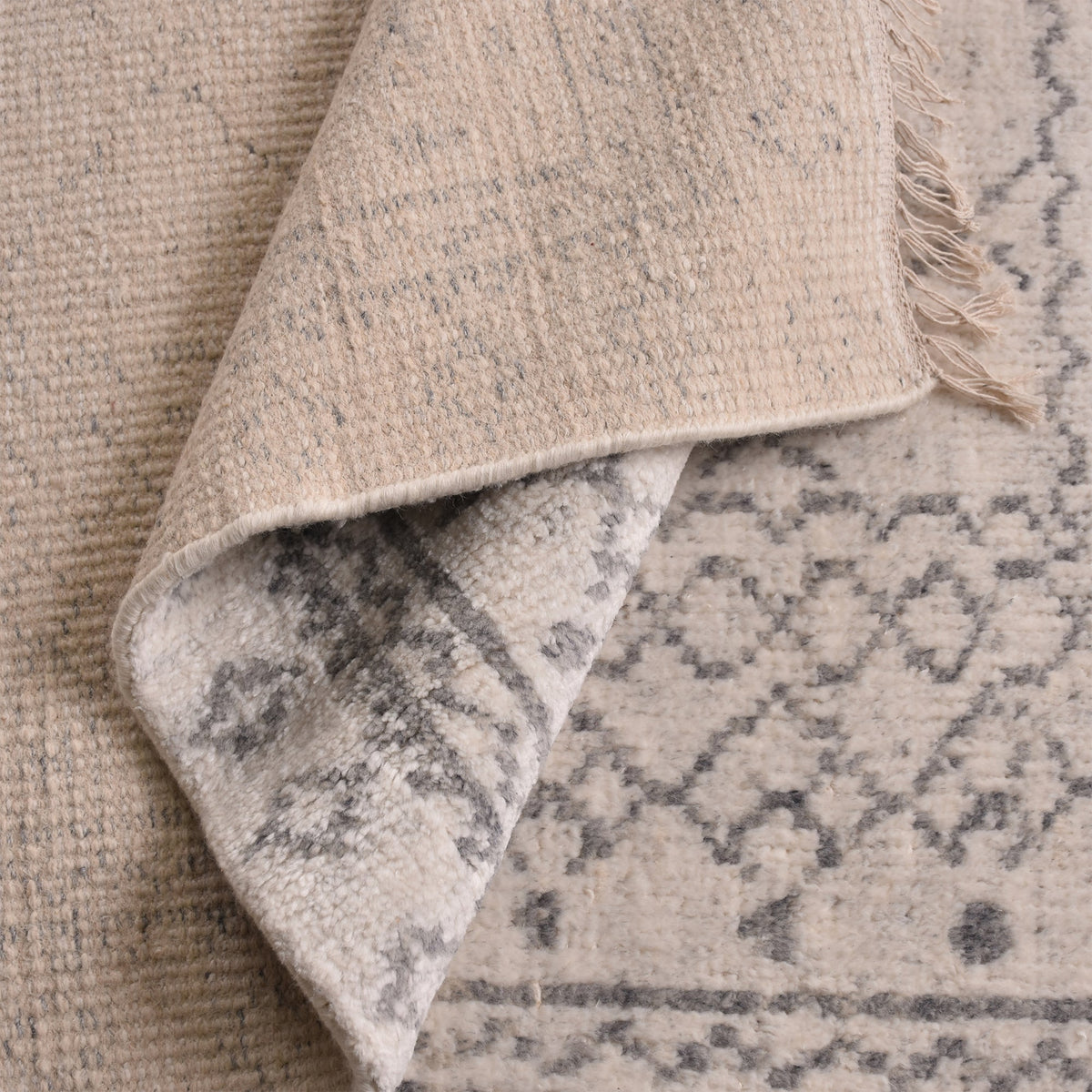Phatak hand-knotted wool rug with an ivory diamond lattice and grey border, in a dining room