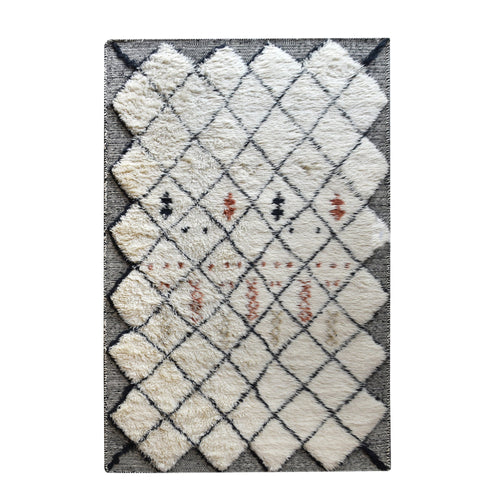 Kesar hand-knotted New Zealand wool shag rug in cream with a black diamond lattice and rust, in a bedroom