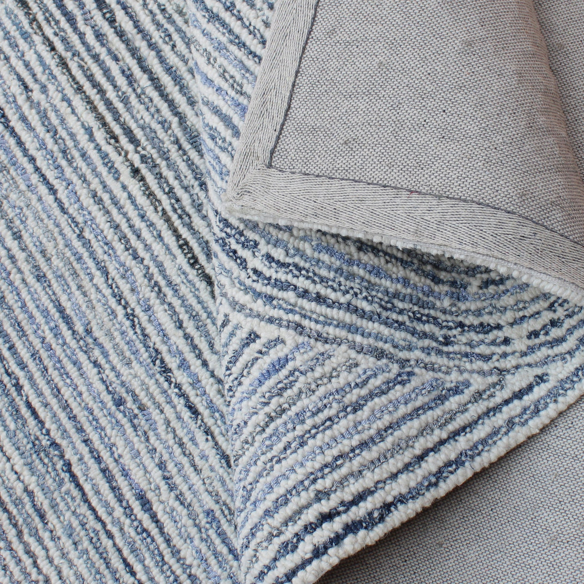 Estuary handwoven wool and denim rug with denim blue contour lines on ivory, in a dining room