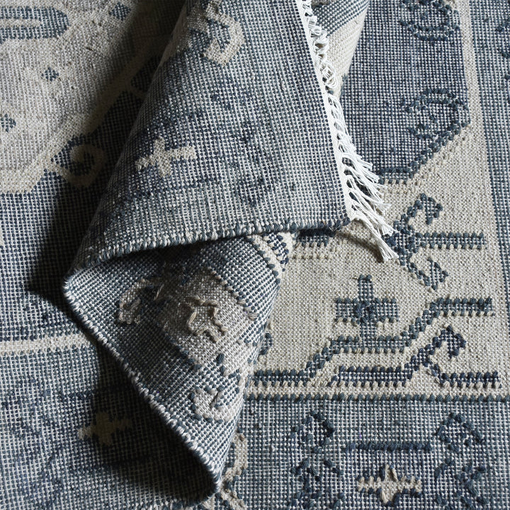 Courtyard flatweave slate blue recycled PET rug with an ivory Heriz medallion, on a patio