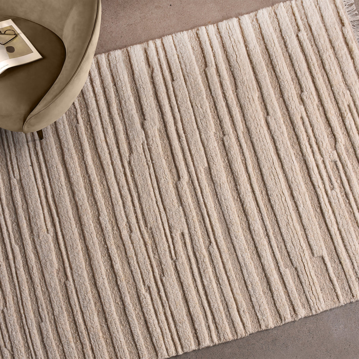 Pankti hand-knotted NZ wool rug in cream and oat with carved vertical stripes, in a dining room