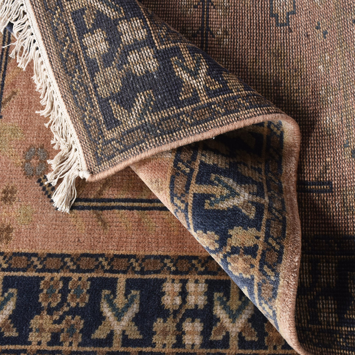 Darbar hand-knotted wool rug with rust and navy Anatolian medallions, in a living room