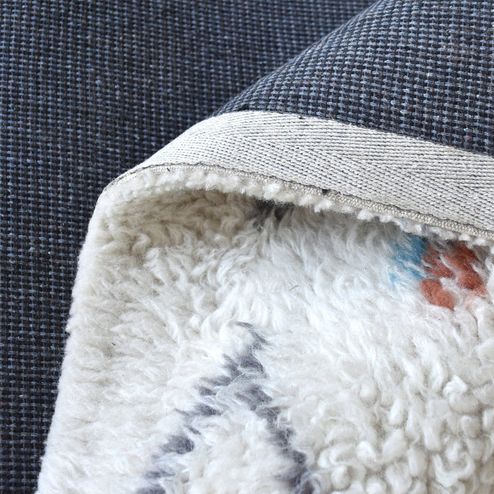 Mela tufted New Zealand wool rug with an ivory lattice and rust, teal and charcoal diamonds