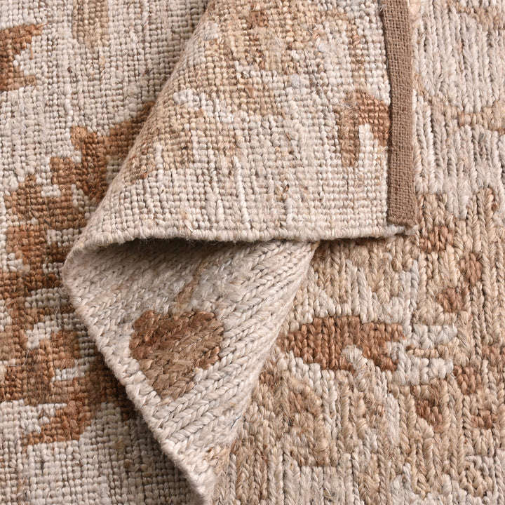 Peony hand-knotted ivory jute rug with faded terracotta florals, in a living room