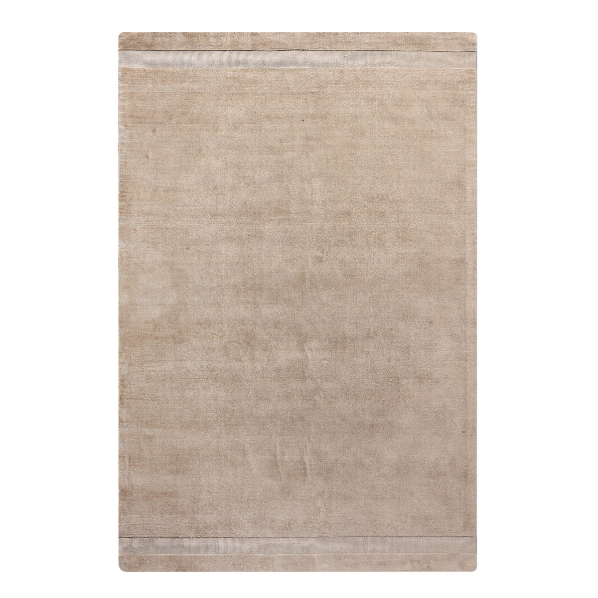 Chamak handwoven viscose rug in plain camel sand with a soft sheen, in a living room