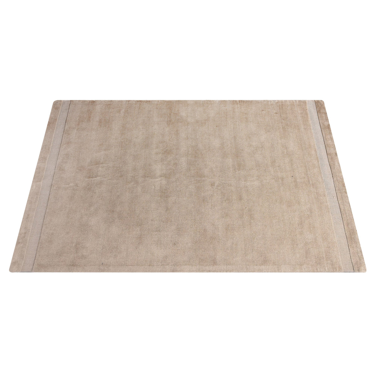 Chamak handwoven viscose rug in plain camel sand with a soft sheen, in a living room