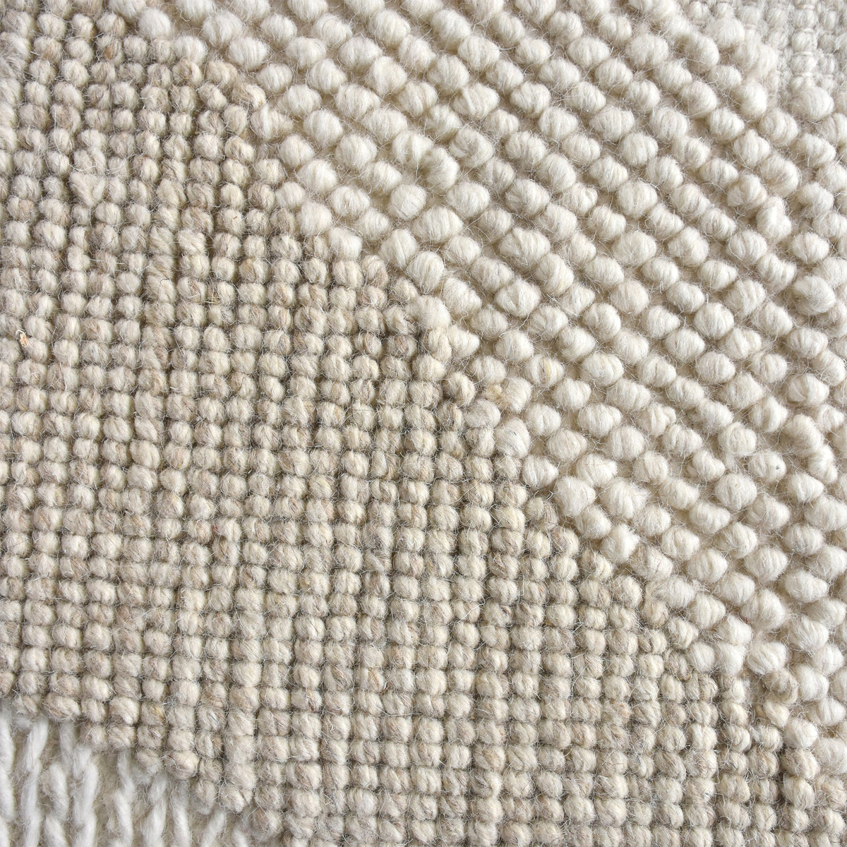 Pahad handwoven greige wool rug with carved contour waves, in a living room