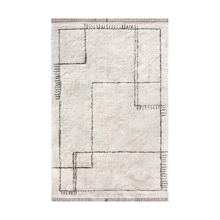 Khaka tufted cotton rug with charcoal outline squares on ivory, in a living room