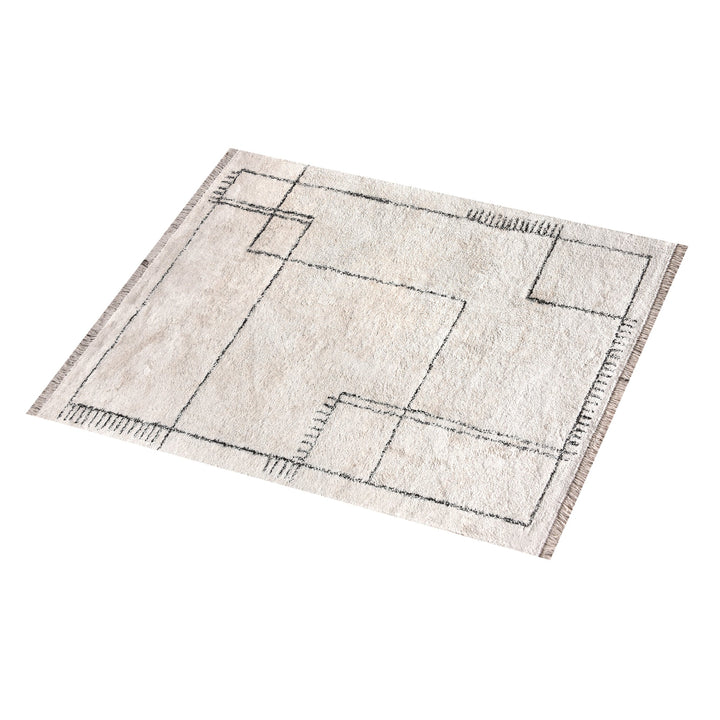 Khaka tufted cotton rug with charcoal outline squares on ivory, in a living room