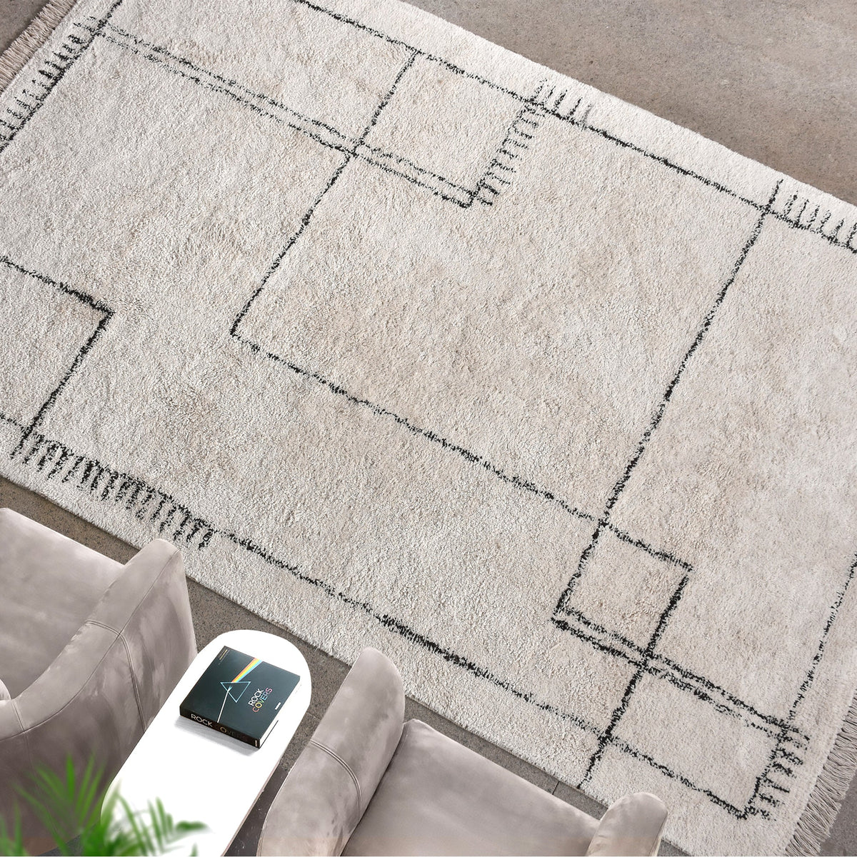 Khaka tufted cotton rug with charcoal outline squares on ivory, in a living room
