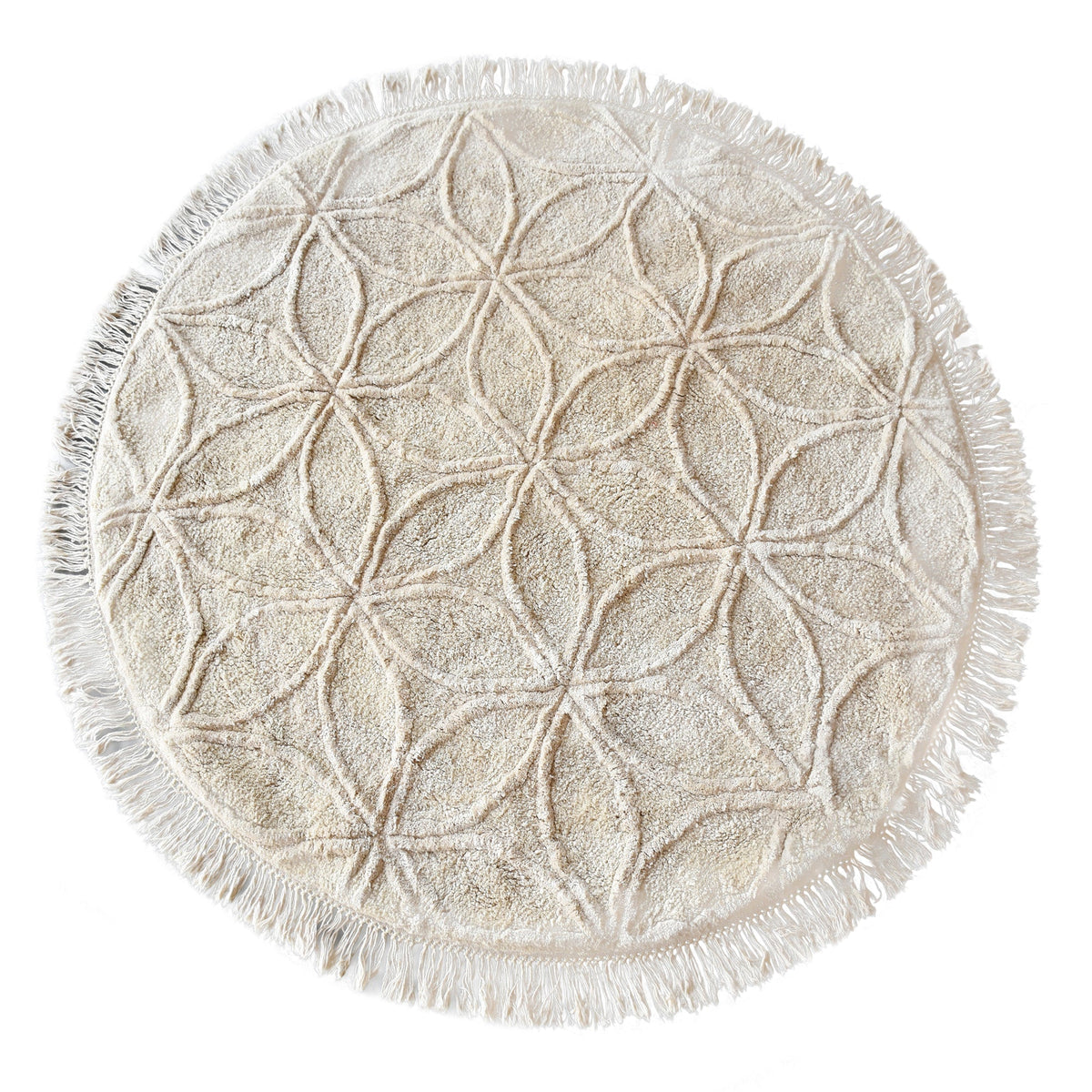 Phool round tufted cotton rug with a flower-of-life motif and fringe in raffia beige, in a bedroom