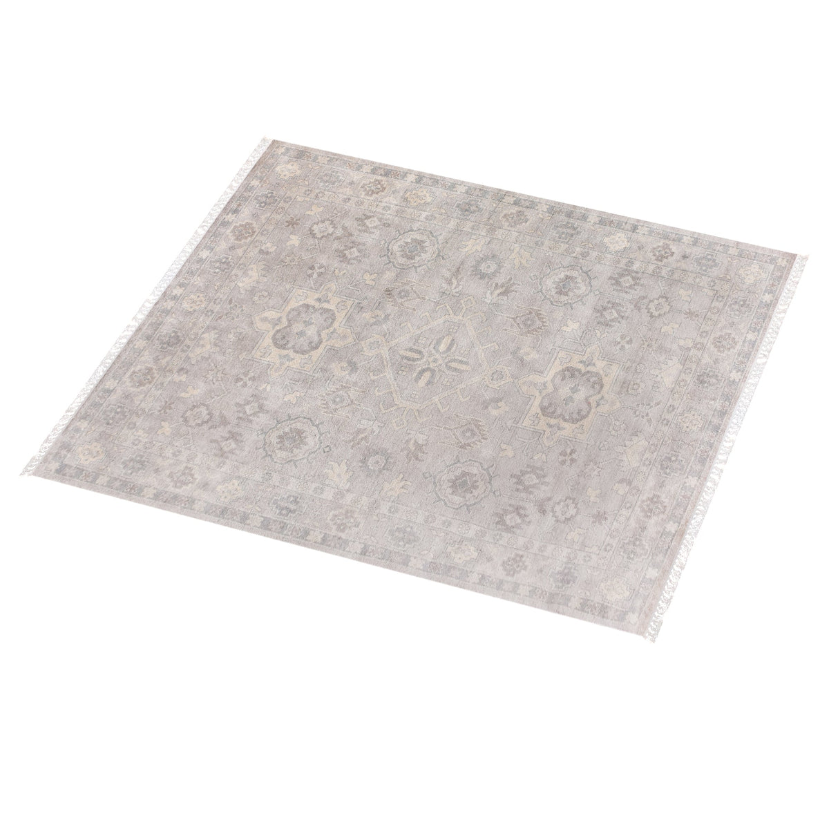 Yaad hand-knotted wool rug with distressed tribal medallions in pale taupe and rust, in a dining room