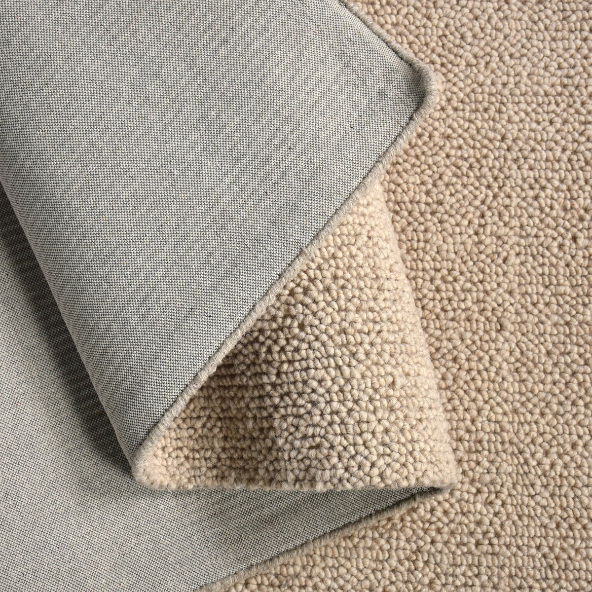 Hopsack flatweave wool rug in light beige with a nubby popcorn weave, in a living room