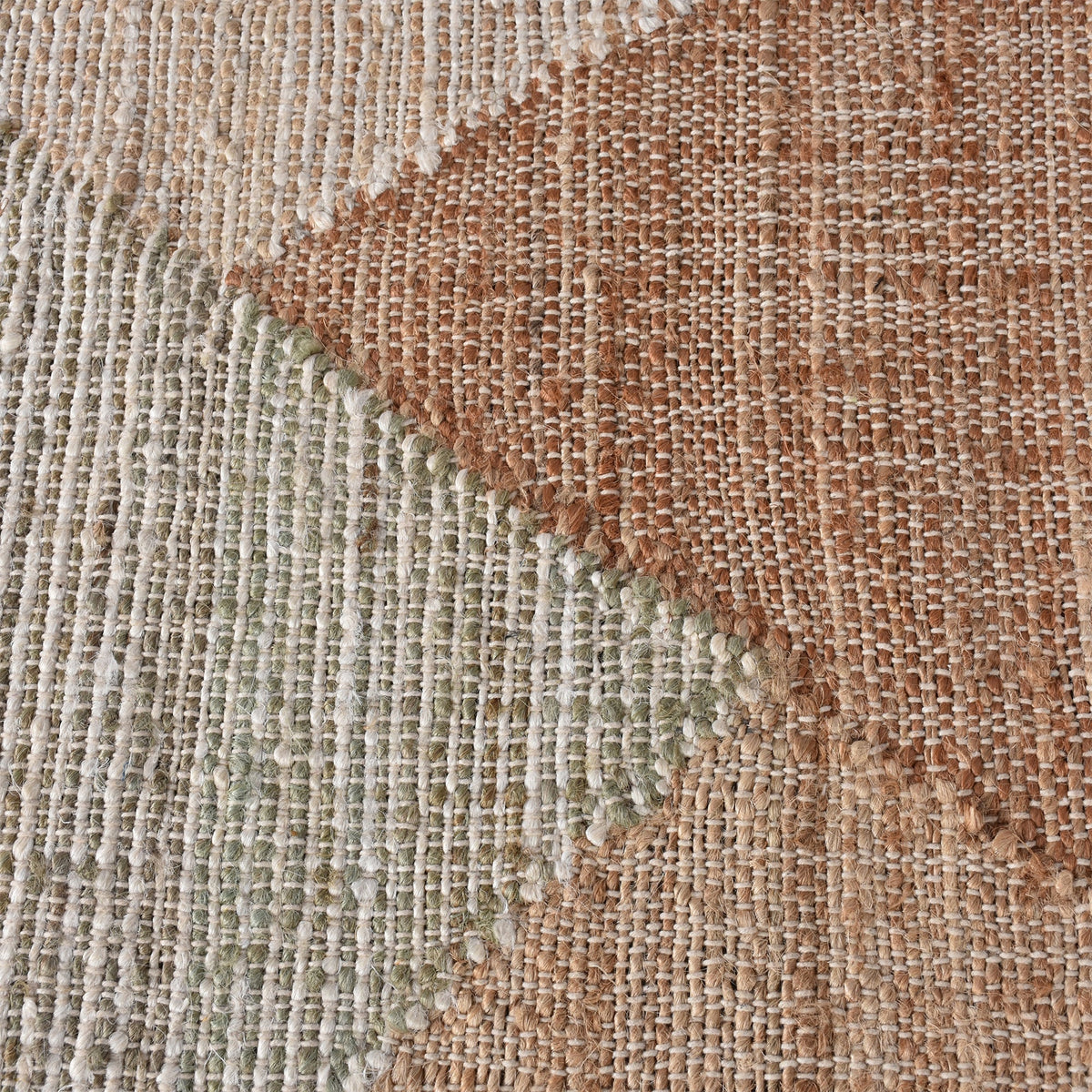 Patang handwoven jute flatweave rug with large blush, tan and grey diamonds, in a bedroom