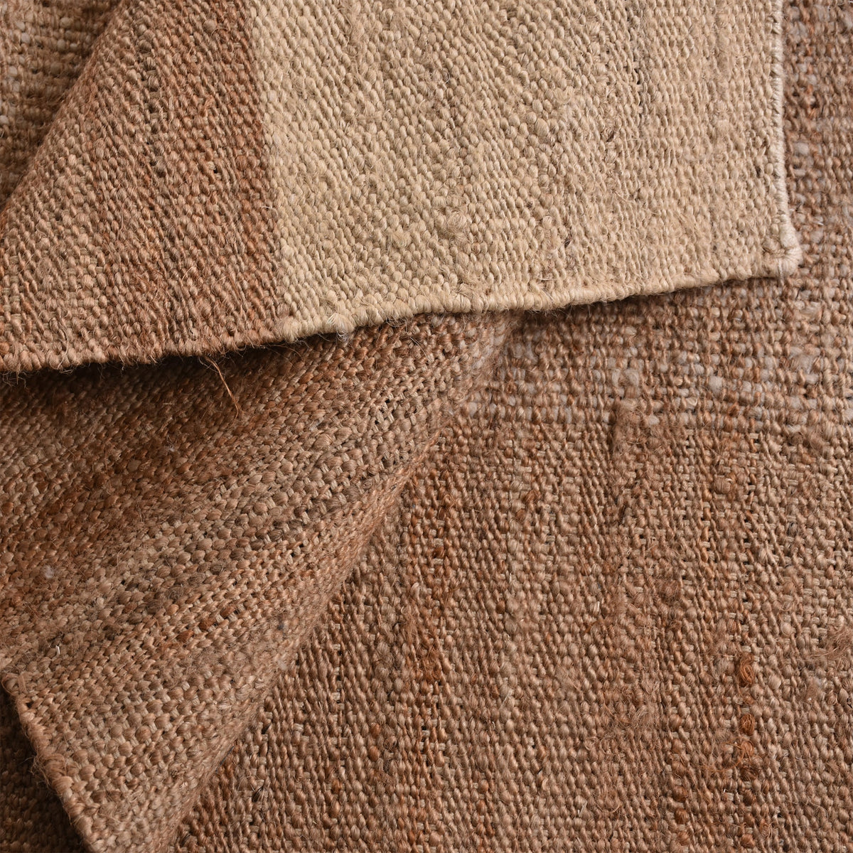 Sunbaked flatweave jute and wool rug in terracotta and blush colour blocks, in a living room