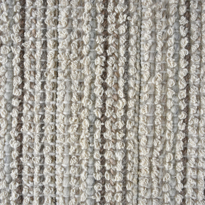 Kinara handwoven wool and jute rug in ivory and beige stripes, in a living room