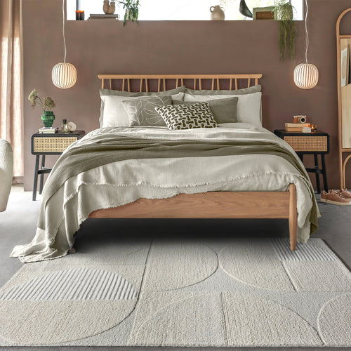 Archway handwoven ivory wool rug with carved arc lines, in a living room