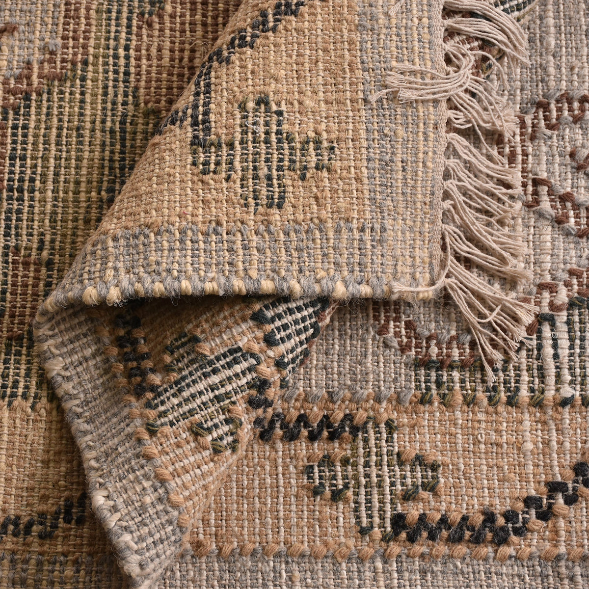Haveli handwoven flatweave jute and wool rug with a faded beige medallion and terracotta border, in a living room