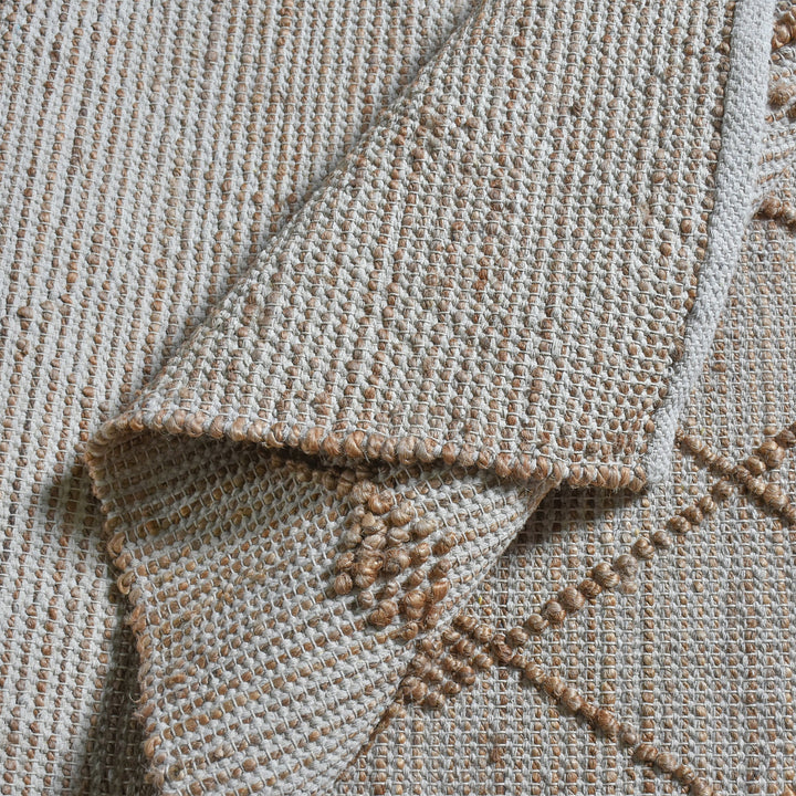 Driftwood handwoven jute rug with natural and grey diamond lattice, in a living room