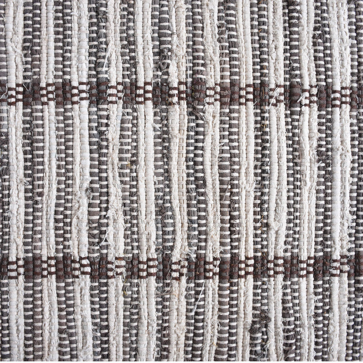 Awning handwoven denim and cotton rug with broad grey and ivory stripes, in a living room