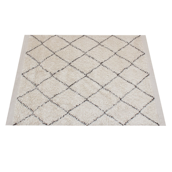 Syahi handwoven wool rug with a charcoal diamond lattice on ivory, in a study