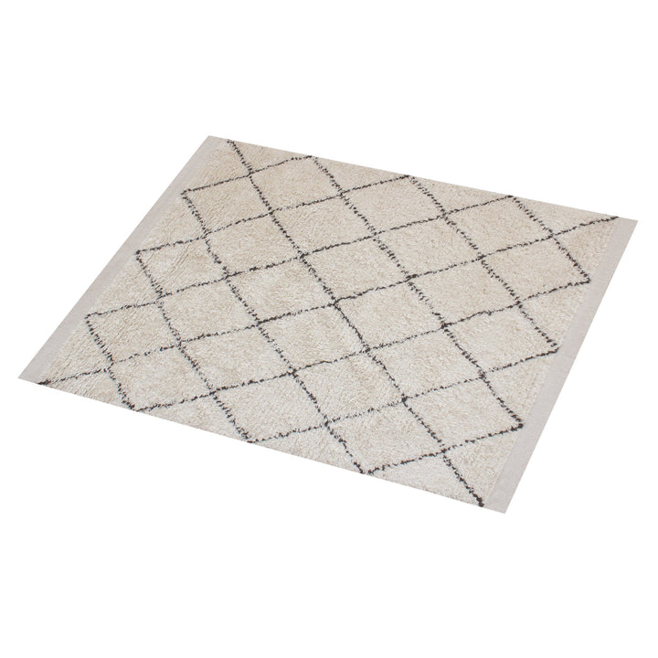 Syahi handwoven wool rug with a charcoal diamond lattice on ivory, in a study