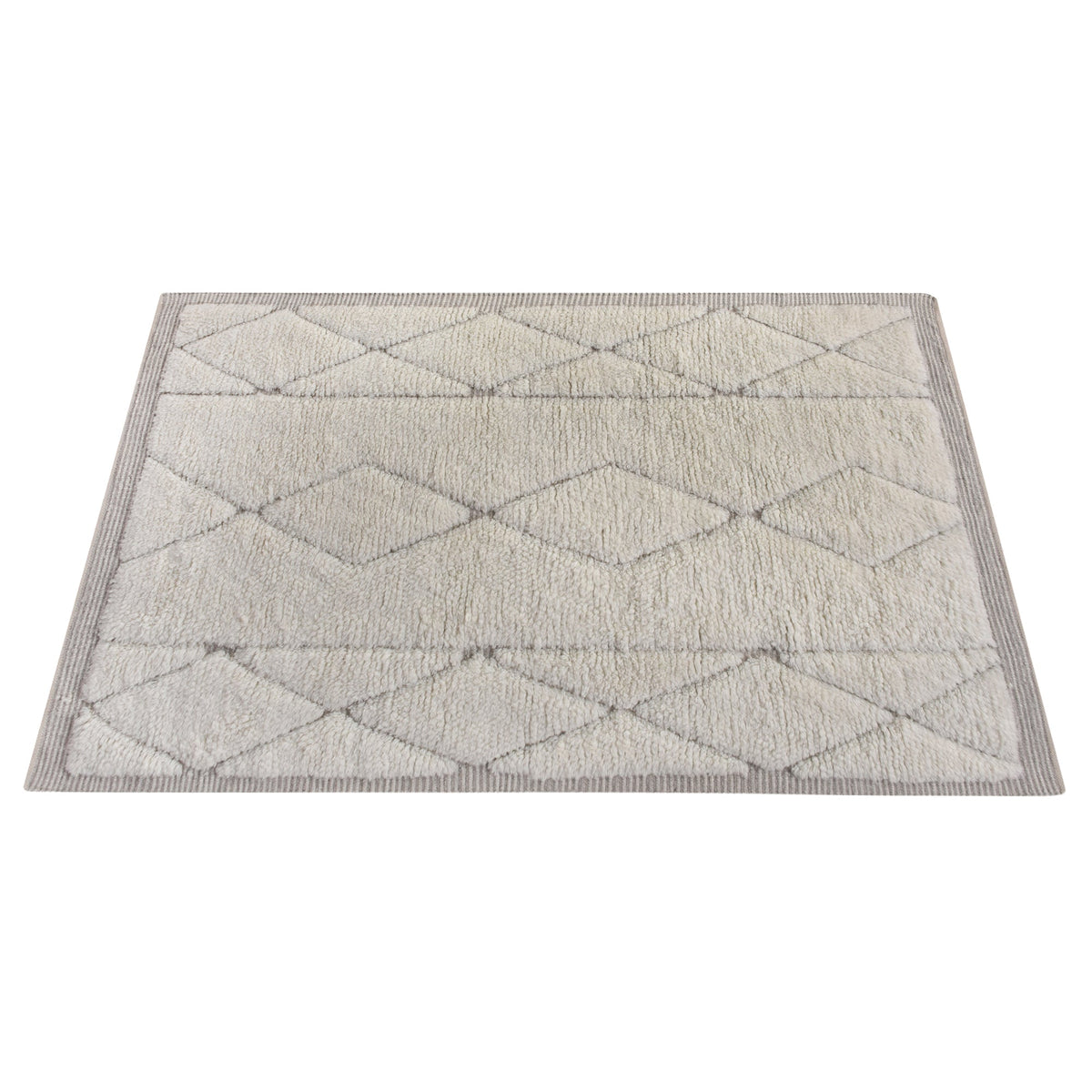 Ola handwoven New Zealand wool rug with an ivory Moroccan diamond lattice and grey, in a living room