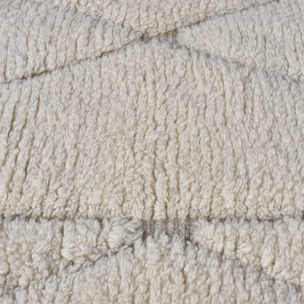 Ola handwoven New Zealand wool rug with an ivory Moroccan diamond lattice and grey, in a living room