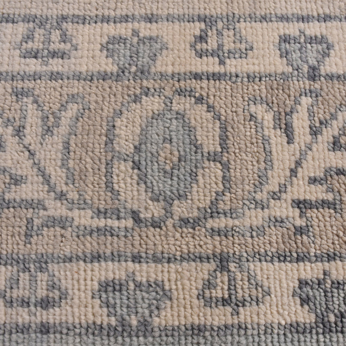 Aab hand-knotted wool rug with a faded blue medallion on an ivory ground, in a living room