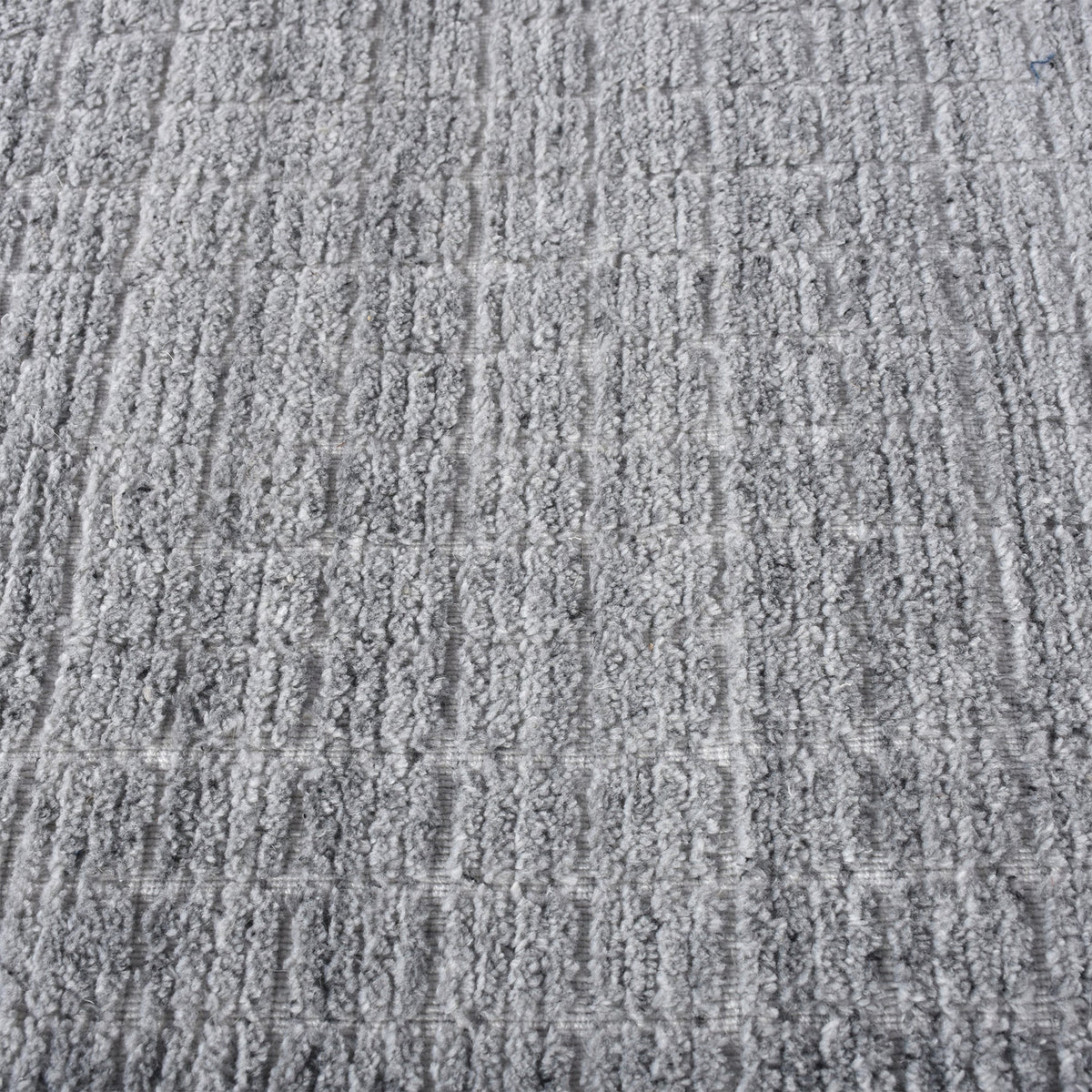 Raakh handwoven flatweave recycled PET rug in plain heather grey with fringe, in a living room
