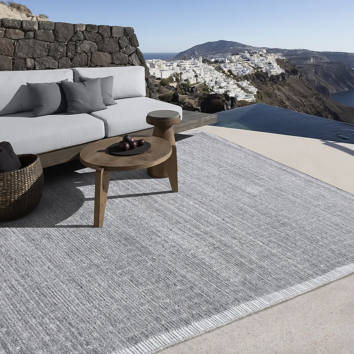 Raakh handwoven flatweave recycled PET rug in plain heather grey with fringe, in a living room