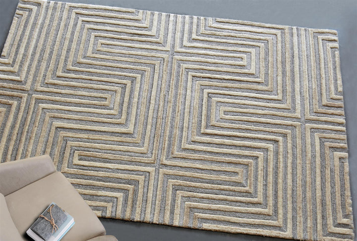 Raasta hand-tufted sand beige wool rug with carved concentric maze lines, in a living room