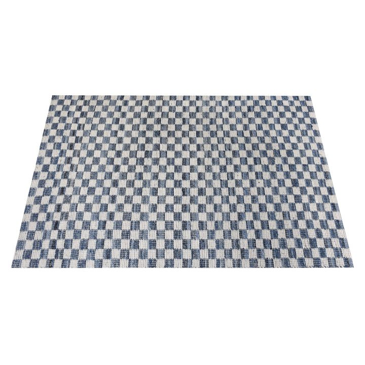 Taash handwoven denim and cotton rug with a navy and ivory checkerboard, in a living room