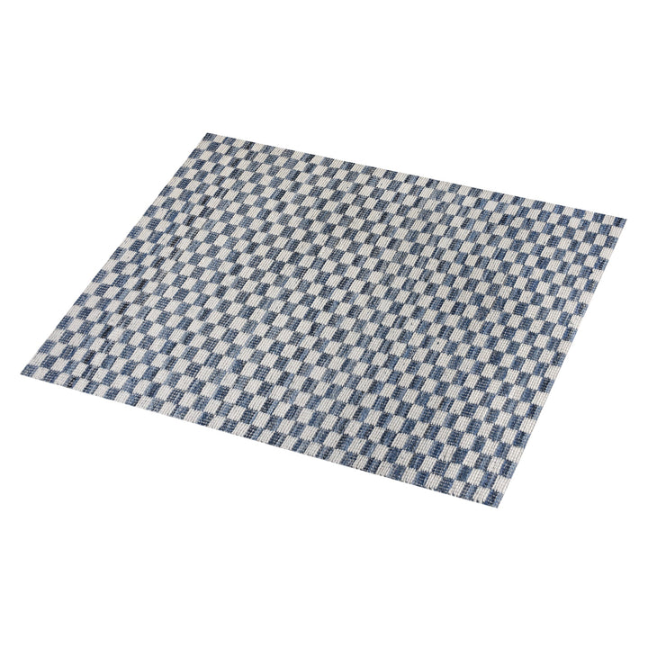 Taash handwoven denim and cotton rug with a navy and ivory checkerboard, in a living room