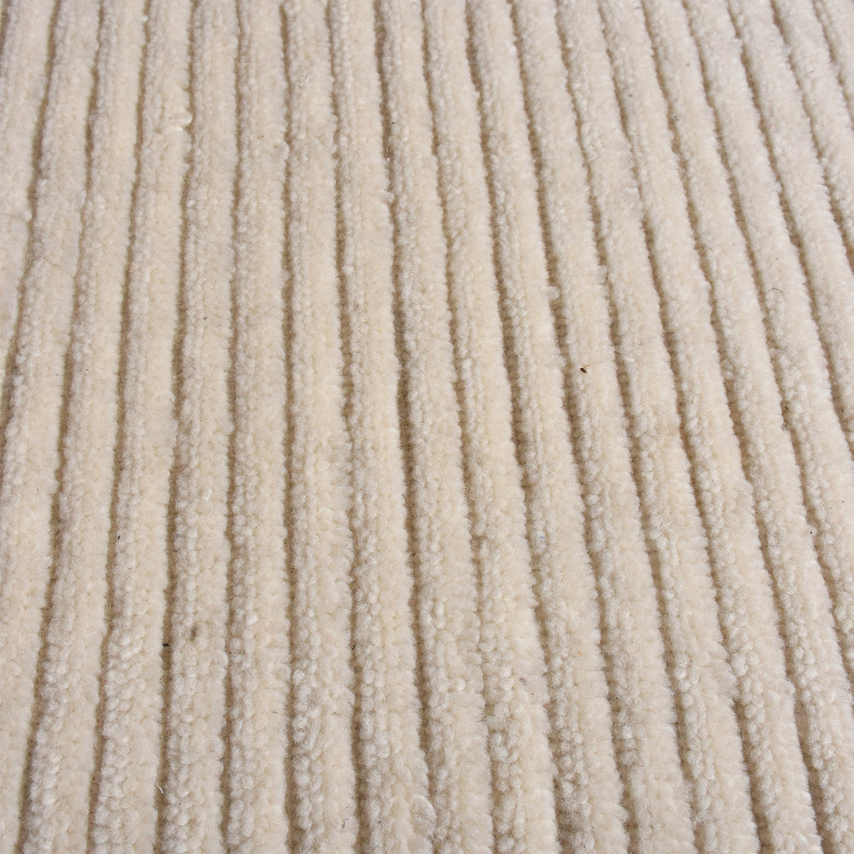 Hal handwoven NZ wool rug in ivory with wide ribbed stripes, in a dining room